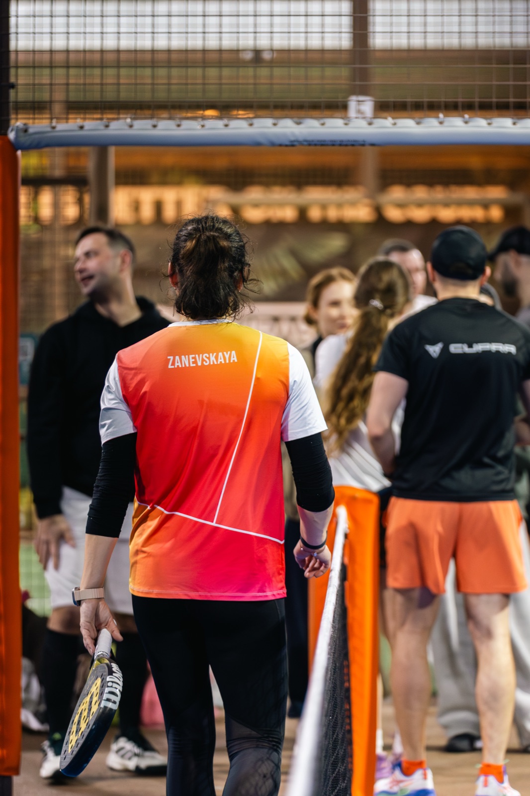 A player walks onto the court, her name printed on the back of the shirt